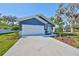 Inviting blue home featuring a well-kept lawn, fresh landscaping, and an attached two-car garage at 2807 W Granfield Ave, Plant City, FL 33563