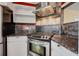Close up of the kitchen showcasing stainless steel gas range, dark countertops, stone backsplash and white cabinets at 3000 2Nd N Ave, St Petersburg, FL 33713