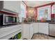 Compact kitchen features white cabinets, granite countertops, stainless steel appliances and stylish backsplash at 3000 2Nd N Ave, St Petersburg, FL 33713