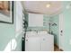 Bright laundry room with a washer, dryer, storage, shelving and mint green colored walls at 3000 2Nd N Ave, St Petersburg, FL 33713