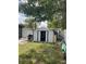 Backyard view of a storage shed with an open door, surrounded by lawn and trees at 3106 W Dewey, Tampa, FL 33607