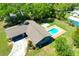 Aerial view of a home with a sparkling in-ground pool and lush, mature landscaping at 37451 Hickory Hill Ln, Dade City, FL 33525