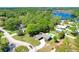 Aerial view of a home with an in-ground pool, mature trees, and a waterfront view at 37451 Hickory Hill Ln, Dade City, FL 33525