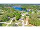 Aerial view of neighborhood featuring mature trees, a pond, and houses with spacious yards at 37451 Hickory Hill Ln, Dade City, FL 33525