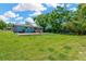 Large grassy backyard with an in-ground pool, mature trees, and a charming deck at 37451 Hickory Hill Ln, Dade City, FL 33525
