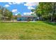 Spacious backyard with a grassy lawn, mature trees, and an in-ground swimming pool at 37451 Hickory Hill Ln, Dade City, FL 33525