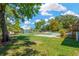 A lush backyard with a grassy lawn and mature trees near the in-ground pool at 37451 Hickory Hill Ln, Dade City, FL 33525