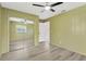 This bedroom features a ceiling fan, gray floors, and a mirror closet at 37451 Hickory Hill Ln, Dade City, FL 33525