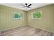 This cozy bedroom features hardwood floors, two windows, and a ceiling fan at 37451 Hickory Hill Ln, Dade City, FL 33525