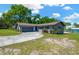 Charming single-story home with a well-maintained lawn and a driveway leading to an attached garage at 37451 Hickory Hill Ln, Dade City, FL 33525