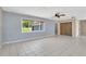 Open-concept living room featuring tiled floors, wood-paneled walls, and an exterior window at 37451 Hickory Hill Ln, Dade City, FL 33525