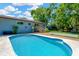 Private backyard with a sparkling in-ground pool, lush lawn, and a backyard deck at 37451 Hickory Hill Ln, Dade City, FL 33525