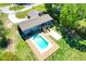 Aerial view of backyard featuring a pool, a grassy yard, and a home with a driveway at 37451 Hickory Hill Ln, Dade City, FL 33525