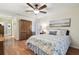 Cozy bedroom with wooden floors, ceiling fan, and natural light streaming through plantation shutters at 3952 Applegate Cir, Brandon, FL 33511
