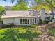Exterior view of a home featuring a bright sunroom, mature hedges, and stone pathway at 3952 Applegate Cir, Brandon, FL 33511