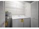 Efficient laundry room featuring washer, dryer, shelving, and water heater for convenience at 39650 Us Highway 19 N # 615, Tarpon Springs, FL 34689