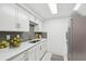 Modern kitchen features white cabinets, a stylish gray backsplash, stainless steel appliances, and ample counter space at 4229 Redcliff Pl, New Port Richey, FL 34652