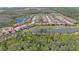 An expansive aerial shows a lakefront community with a mix of homes and lush landscaping at 4782 Night Star Trl, Odessa, FL 33556