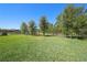 Manicured backyard with black fence leading to the lake view at 4782 Night Star Trl, Odessa, FL 33556