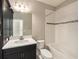 Bathroom with dark vanity, stone countertop, and shower-tub with white tiles at 4782 Night Star Trl, Odessa, FL 33556