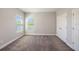 Neutral bedroom featuring carpeted floors, window views, and white doors at 4782 Night Star Trl, Odessa, FL 33556