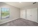Bedroom view featuring carpeted floors, window views, and closet doors at 4782 Night Star Trl, Odessa, FL 33556