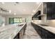 Kitchen featuring an island with marble countertops and dark wood cabinets, stainless steel appliances, and tile floors at 4782 Night Star Trl, Odessa, FL 33556