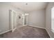 Carpeted room with double glass doors and a view of the hallway; chandelier light fixture at 4782 Night Star Trl, Odessa, FL 33556