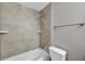 Bright bathroom featuring a tub with shower and neutral ceramic tile surround at 5159 Sterling Manor Dr, Tampa, FL 33647