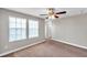 The bedroom features carpeted floors, a ceiling fan, and two windows to bring in natural light at 5159 Sterling Manor Dr, Tampa, FL 33647