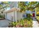 Charming home exterior featuring a two-car garage, red front door, and lush landscaping at 5159 Sterling Manor Dr, Tampa, FL 33647