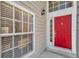 Bright red front door with classic hardware and sidelight window at 5159 Sterling Manor Dr, Tampa, FL 33647