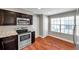 Modern kitchen featuring stainless steel appliances, dark cabinetry, and wood-look flooring at 5159 Sterling Manor Dr, Tampa, FL 33647