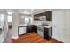Modern kitchen featuring stainless steel appliances, dark cabinetry, and wood-look flooring at 5159 Sterling Manor Dr, Tampa, FL 33647