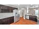 Spacious kitchen featuring stainless steel appliances, dark cabinets, and wood-look floors at 5159 Sterling Manor Dr, Tampa, FL 33647