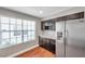Bright kitchen featuring stainless steel refrigerator, dark cabinetry, and a window with natural light at 5159 Sterling Manor Dr, Tampa, FL 33647