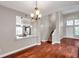Living room with wood floors, view to kitchen, staircase, and natural light at 5159 Sterling Manor Dr, Tampa, FL 33647