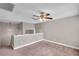 Carpeted loft area with neutral walls, white trim, a ceiling fan and a light fixture hanging in the corner at 5159 Sterling Manor Dr, Tampa, FL 33647