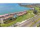 Beautiful aerial view of community with beach access, tennis courts, a pool, and green space at 5625 Escondida S Blvd, St Petersburg, FL 33715