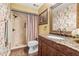 Updated bathroom featuring granite counters, a tiled shower, and decorative wallpaper at 5625 Escondida S Blvd, St Petersburg, FL 33715