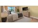 Tastefully staged bedroom with a neutral palette, a large dresser, and sliders to the balcony at 5625 Escondida S Blvd, St Petersburg, FL 33715