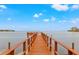 Waterfront view from end of long, private wooden dock with expansive ocean views under a partly cloudy sky at 5625 Escondida S Blvd, St Petersburg, FL 33715