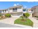Charming two-story townhouse featuring manicured landscaping, a brick-paved driveway, and an attached garage at 5625 Escondida S Blvd, St Petersburg, FL 33715