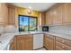 This kitchen features stainless steel appliances, wood cabinets, tile backsplash, and a window view to the golf course at 5625 Escondida S Blvd, St Petersburg, FL 33715