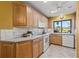This kitchen offers tile backsplash, white appliances, wood cabinets, and a window view to the golf course at 5625 Escondida S Blvd, St Petersburg, FL 33715