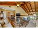 Inviting living room with vaulted ceilings, exposed beams, and a view of the balcony and golf course at 5625 Escondida S Blvd, St Petersburg, FL 33715