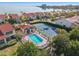 Aerial view showcasing the community pool and tennis courts surrounded by lush landscaping near waterfront property at 5625 Escondida S Blvd, St Petersburg, FL 33715