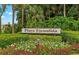 Charming community entrance sign 'Playa Escondida' surrounded by vibrant flowers and lush greenery at 5625 Escondida S Blvd, St Petersburg, FL 33715