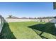 Spacious backyard with a pristine lawn, white fence, and play set at 6236 Dutton Dr, Wesley Chapel, FL 33545
