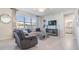 Cozy living room with a plush sofa, recliner, and a large window overlooking the backyard at 6236 Dutton Dr, Wesley Chapel, FL 33545